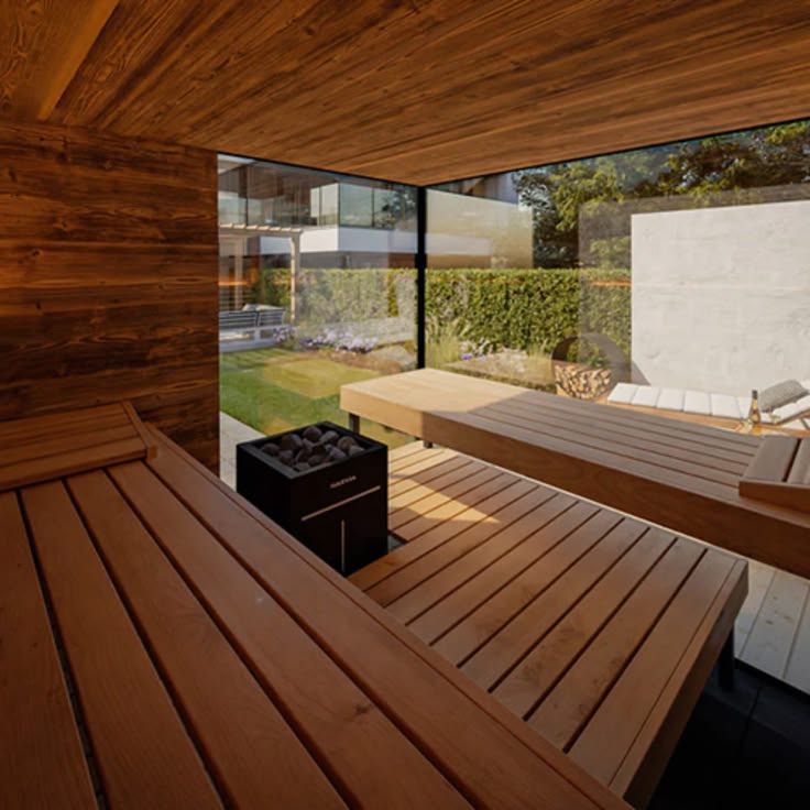 Cedar sauna interior with a rock heater and a garden window