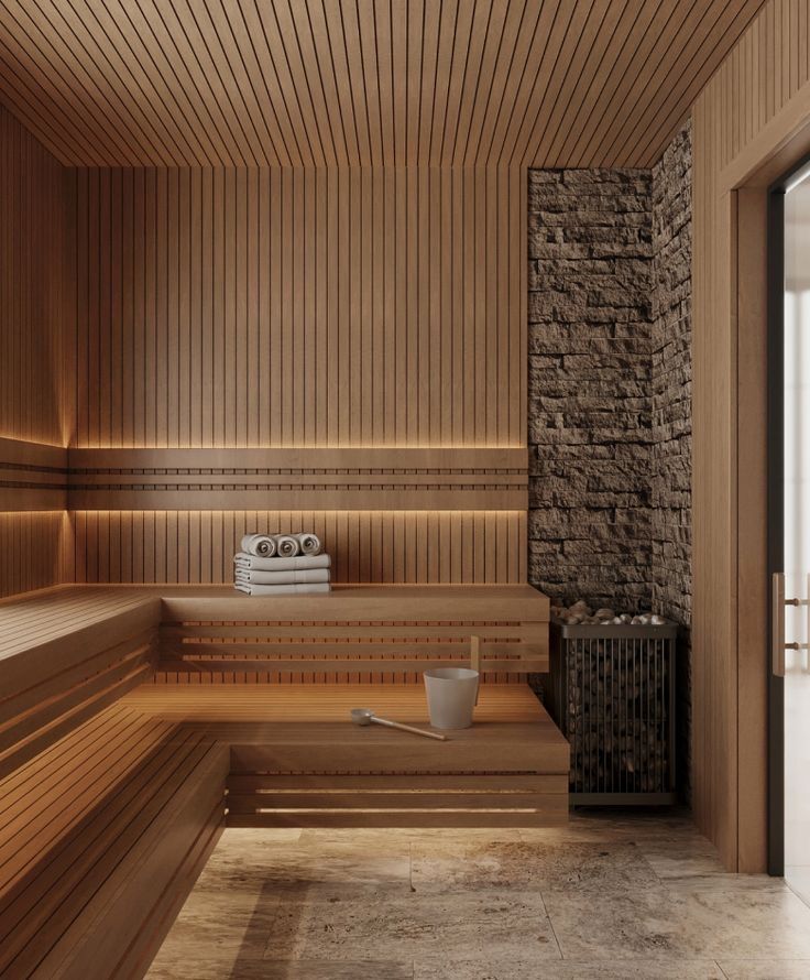 Warm cedar sauna interior with a stone accent wall, a stone-filled heater, and a travertine floor