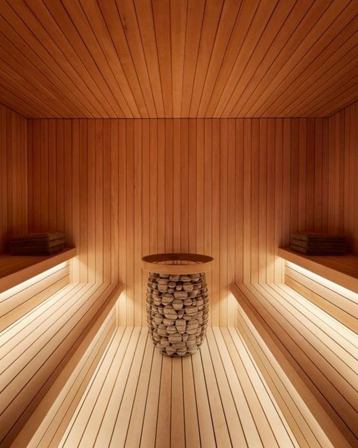 Solid cedar sauna interior with facing benches and a central stone heater