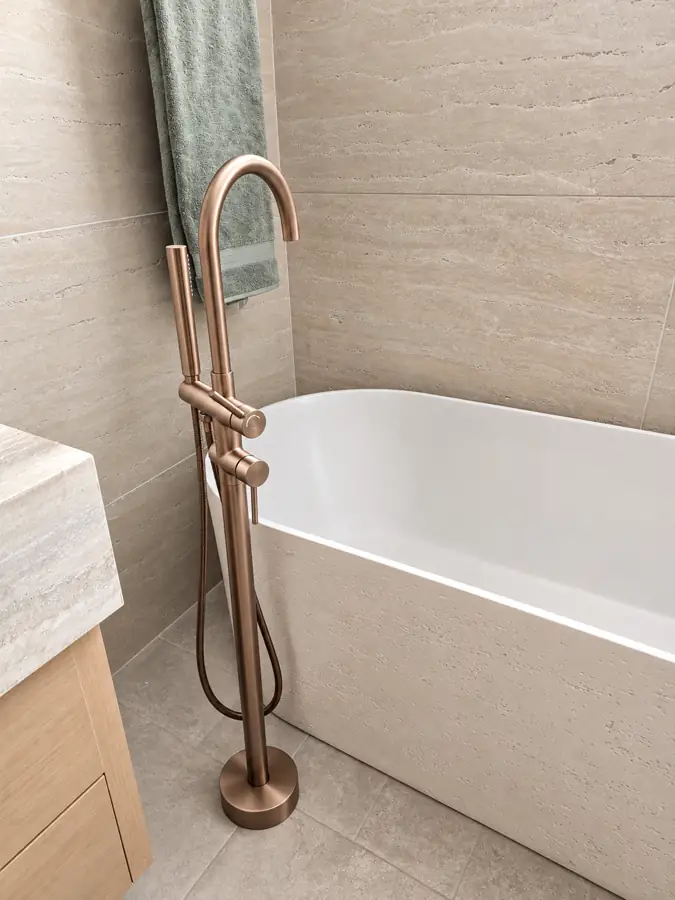 Bathrooms: Freestanding travertine tub and the rose gold filler