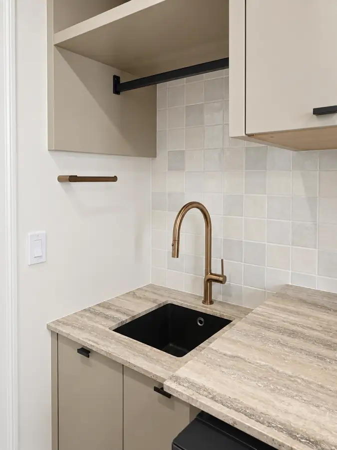 Laundry and bonus room: Laundry sink, rose gold faucet, hanging rod