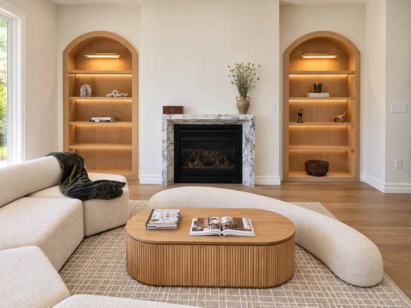 Living room, furnished: the fireplace with an arched bookcase either side